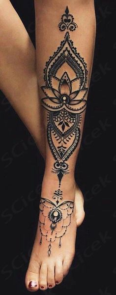 a woman's foot with an intricate tattoo design on the top and bottom of it