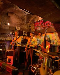 three men are playing instruments in a bar