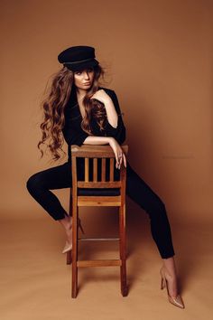 a woman sitting on top of a wooden chair