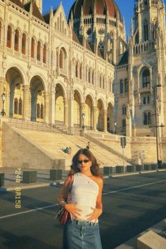 a woman standing in front of a large building