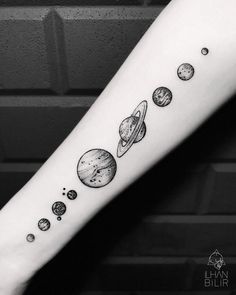 an arm tattoo with planets on it