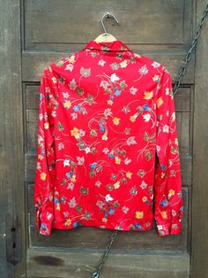 "The most perfect vintage 70's polyester red daffodil and leaf print polyester button down top. Great for fall! No tag. Great vintage condition! Size medium. Measurements laying flat: fabric stretches a bit. Armpit to armpit: 18.5\" Length: 23\" Sleeve length: 22\"" Retro Red Floral Print Shirt, Red Retro Floral Print Shirt, Red Vintage Shirt With Vintage Print, Red Floral Print Retro Shirt, Red Vintage Print Shirt, Vintage Floral Print Shirt For Fall, Vintage Red Shirt With Floral Print, Vintage Red Blouse For Fall, Vintage Red Shirt For Fall