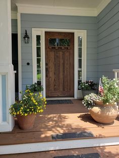 two potted plants on the front steps of a house