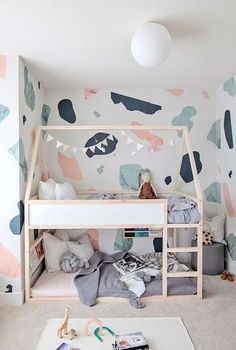 a child's bedroom with a bunk bed and colorful wallpaper