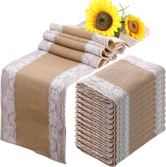 a stack of burlap and lace table runners with sunflowers