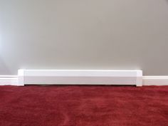 a red carpeted room with a white radiator