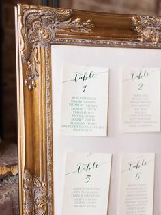 the seating cards were placed on top of each other in an ornate gold framed frame