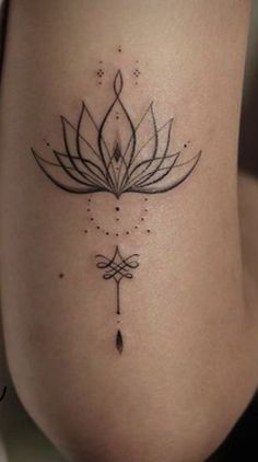 a woman's thigh with a lotus tattoo on her stomach and an arrow in the middle