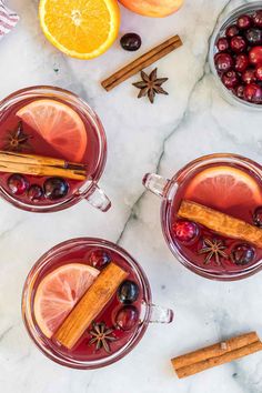 three glasses of cranberry orange punch garnished with cinnamon and star anise