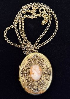 "Vintage Danecraft 12K Gold Filled Oval Cameo Locket. The top face of the locket has a hand engraved design with an applied filigree design framing the hand carved cameo. The necklace bail has a matching filigree design. Chain and Locket Marked: Danecraft 12k GF Locket measures approximately 2\" x 1.5\" Chain measures approximately 24\" long VERY GOOD USED CONDITION WITH MINIMAL WEAR FROM AGE AND USE PLEASE VIEW ALL PHOTOS AND ASK ANY QUESTIONS BEFORE PURCHASING!" Luxury Heirloom Oval Necklace, Luxury Hallmarked Oval Pendant Locket Necklace, Luxury Engraved Victorian Jewelry, Luxury Cameo Medallion Necklace, Luxury Vintage Etched Necklaces, Luxury Vintage Hallmarked Locket Necklace, Luxury Ornate Oval Pendant Necklace, Luxury Antique Oval Locket Necklace, Luxury Engraved Oval Cabochon Jewelry