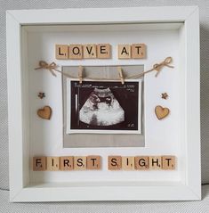 a white frame with scrabbles and words that spell out love at first sight