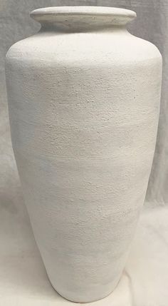 a large white vase sitting on top of a table