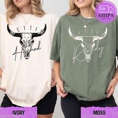 two women wearing t - shirts with long horns on them and the same one has an image of a cow's head