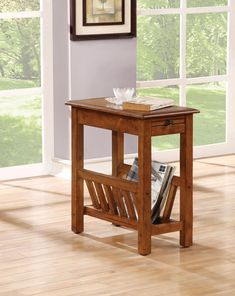 a small wooden table with magazine rack on the bottom and magazines in front of it