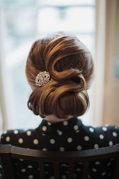 a doll sitting in a chair wearing a polka dot dress with a hair comb on her head