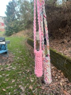 some pink and white rope hanging from a tree