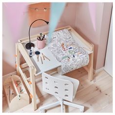 a child's desk and chair in the corner of a room with pink walls