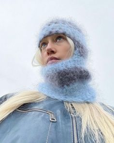 a woman with blonde hair wearing a blue hat and scarf