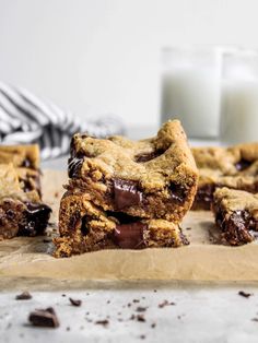 chocolate chip cookie bars stacked on top of each other next to a glass of milk