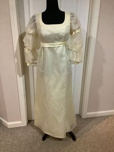 This nice vintage 60s Emma Domb Bone high waist Romantic Prairie puff sleeves Party Ball Wedding dress comes to you in a size S-M. The dress is satin underneath and then has a overlay on top of it. On bodice area there is embroidery there. The sleeves are my favorite part of the dress. Pls compare the measurements I give you to those in your closet. Regency ball dress Dapne. Fitted A-line Puff Sleeve Wedding Dress, Spring Banquet Vintage Dress, Vintage Fitted Dress For Banquet, Fitted Bishop Sleeve Dress For Banquet, Vintage Dress With Fitted Lantern Sleeves, Vintage Dress With Lantern Sleeves, Vintage Fitted Dress With Lantern Sleeves, Fitted Victorian Dress For Spring Party, Elegant Vintage Puff Sleeve Wedding Dress