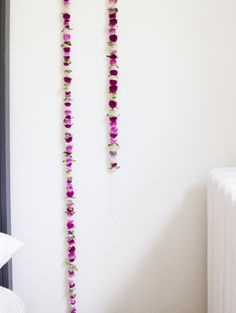 two flowers are hanging on the wall next to a radiator