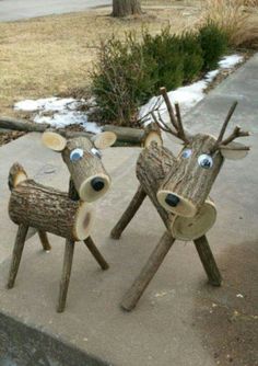 two wooden deer sculptures sitting on top of a sidewalk