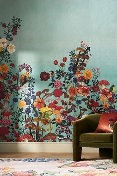 a living room with floral wallpaper and green chair in front of the colorful flowered wall