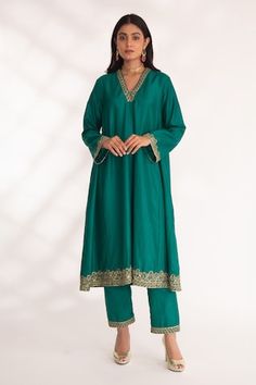 Emerald green A-line kurta featuring zardozi hand embroidery on the neckline, sleeve and ghera hem. Paired with a straight pant. - Aza Fashions Green Raw Silk Palazzo Set With Dabka, Ceremonial Anarkali Style Raw Silk Kurta, Ceremonial Green Raw Silk Kurta, Green Ceremonial Kurta For Navratri, Ceremonial Green Kurta For Navratri, Ceremonial Green Kurta With Resham Embroidery, Green Kurta With Dabka Work For Ceremonial Occasions, Ceremonial Green Kurta With Dabka Work, Green Salwar Kameez For Ceremonial Occasions