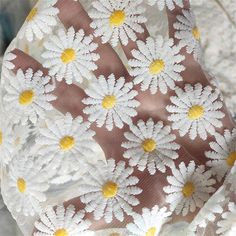 white and yellow flowers are on the fabric