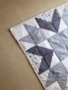 a blue and white quilt on the floor