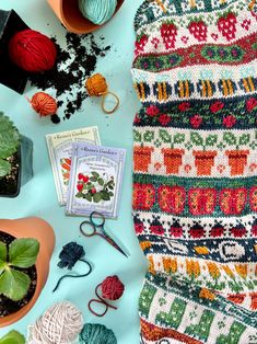 knits and crochet supplies laid out on top of a blue tablecloth