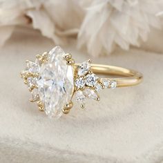 a gold ring with an oval cut diamond surrounded by smaller round diamonds