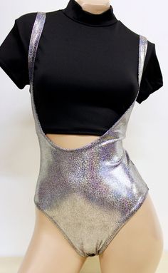 "Our super popular Suspender suit is now available in HOLOGRAM!! It has the sexiest cut, made so that the straps act as \"suspenders.\" The back of the suit is a bit smaller than \"full\" back. Looks cute and has a retro 80's feel. Get playful and add your own top or bandeau. Cut off a tee or tank and wear it with this suit. Be unique!! Made of 4-way stretch metallic swimsuit lycra. ALL HANDMADE in the USA This listing does NOT come with the crop top. Just the suit! Color: SILVER HOLOGRAM *Size Bodysuit Cosplay, Metallic Swimsuit, Swimsuit Cosplay, Pole Dance Wear, Pole Dancing Clothes, Metallic Bodysuit, Dancers Outfit, Rave Outfit, 80s Style