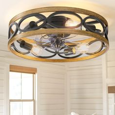 a light fixture in a room with white walls and wood trim around the ceiling,