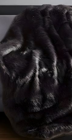 a black and white fur blanket sitting on top of a couch