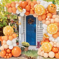 an orange and white balloon arch in front of a house