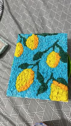 a blue rug with yellow flowers on it and a green bowl sitting next to it