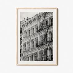 a black and white photo of a fire escape in front of a building with balconies