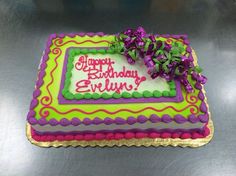 a birthday cake with purple and green decorations