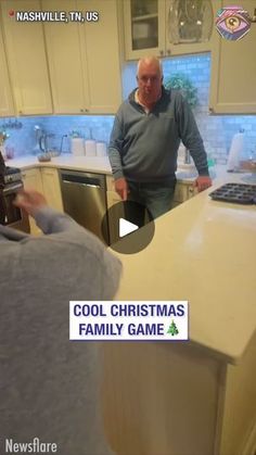 a man standing in a kitchen next to a counter with a christmas tree on it