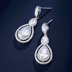 A delightfully unique pair of bridal earrings with an incredible sparkle! Adorned with flawlessly faceted cubic zirconia that capture the light in a dazzling array of sparkles, the earrings are rhodium plated for a bright finish which enhances the intricate detailing and conveys a modern take on old elegance. Overall length of the earring is 1.5" (approx. 4cm). Available in Silver, Rose Gold and Yellow Gold finishes. To make your choice select your preferred finish from the dropdown menu to add White Crystal Earrings With Diamond Accents, Glamorous Diamond White Brilliant Cut Earrings, Dazzling Brilliant Cut Crystal Earrings For Wedding, Pear-shaped Diamond Bridal Earrings With Sparkling Stones, Elegant Brilliant Cut Chandelier Earrings In Cubic Zirconia, Formal Chandelier Earrings With Brilliant Cut Cubic Zirconia, Elegant Brilliant Cut Cubic Zirconia Chandelier Earrings, Elegant Chandelier Earrings With Brilliant Cut Cubic Zirconia, Wedding Earrings With Brilliant Cut Cubic Zirconia