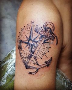 an anchor and compass tattoo on the arm