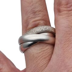 Three-band rolling ring known as a trinity ring, consists of three intertwined sterling silver rings for women, each ring with different finishes. Of contemporary manufacture. Please see all the details of this ring. Weight: 13.68 grams. Dimensions: Each ring separately has an internal diameter between 21.5 and 21.9 mm, but when you put it on your finger it makes approximately 18.2 mm that would correspond to a size 8 - 8 1/2 in the USA, it is difficult to determine since it has movement. Composition: ** Silver, stamped, also acid tested. Do not hesitate to request all the extra information you need, we will be happy to answer you. See photos for your own impression (please note photos were taken in artificial light so colors may differ) All the items we sell have their own personality, th Elegant Twisted Stackable Rings As Gift, Elegant Twisted Stackable Promise Rings, Elegant Twisted Promise Rings, Elegant Twisted Adjustable Stackable Rings, Elegant Metal Wide Band Ring For Anniversary, Elegant Adjustable Twisted Stackable Rings, Elegant Adjustable Twisted Ring, Elegant Wide Band Metal Ring, Elegant White Gold Metal Ring