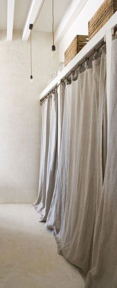 the curtains are hanging in front of the window and behind them is a white wall