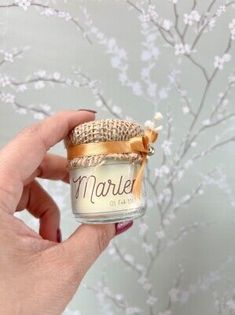 a hand holding a small jar filled with candles