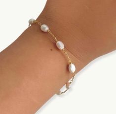 This dainty gold plated bracelet features alternating oval pearls, making it a timeless piece that will never go out of style. Whether you're looking for a subtle addition to your everyday look or a statement piece for a special occasion, the pearl chain bracelet is the perfect choice. It is dainty and elegant also perfect for wedding day or for bridesmaids gift.   PRODUCT DETAILS  Size: 6.2 inch length + 1 inch extension  Material : freshwater pearls and 18k double gold plated 925 silver chain. packaged in ILLÁRI jewelry box  free cleaning cloth included  visit our website www.shopillari.com  POLICY  30 day return policy for unworn and not damaged . shipping is paid by you for all returns. Adjustable Dainty Pearl Drop Bracelet, Dainty Adjustable Beaded Bracelets With Pearl Chain, Dainty Adjustable Bracelet With Pearl Drop, Dainty Adjustable Pearl Drop Bracelet, Dainty Gold-plated Pearl Chain Bracelet, Dainty Adjustable Pearl Chain Bracelet, Dainty Adjustable Pearl Bracelet, Dainty Gold-plated Bracelets With Pearl Charm, Dainty Gold Plated Bracelets With Pearl Charm