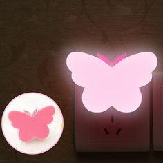 a pink butterfly shaped light next to a white plate with a pink butterfly on it