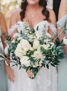 the bridesmaids are holding their bouquets with white flowers