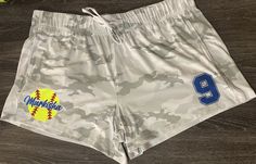 Each pair of women's/teenagers shorts is personalized with your favorite ballers name and number. These athletic shorts are soft and are able to be tied as well. I love the white and gray camo print on the shorts. This pair of shorts is perfect to wear in the house as pajama shorts, out of house to practice or workout in. It is the perfect holiday gift such as christmas or even a birthday gift for a softball player. Shorts are made with 85% cotton and 15% spandex.  Machine wash cold. Tumble dry Casual Cheerleading Shorts, Casual Shorts For Cheerleading, Casual Shorts For Cheerleading During Sports Season, Casual White Athletic Shorts For Cheerleading, Team Spirit Athletic Shorts For Summer, Summer Team Spirit Athletic Shorts, White Team Spirit Athletic Shorts For Sports, White Athletic Shorts For Sports With Team Spirit, Athletic Sports Shorts With Team Name