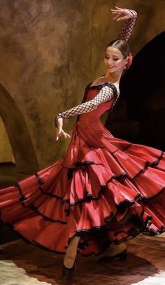 a woman in a red dress is dancing